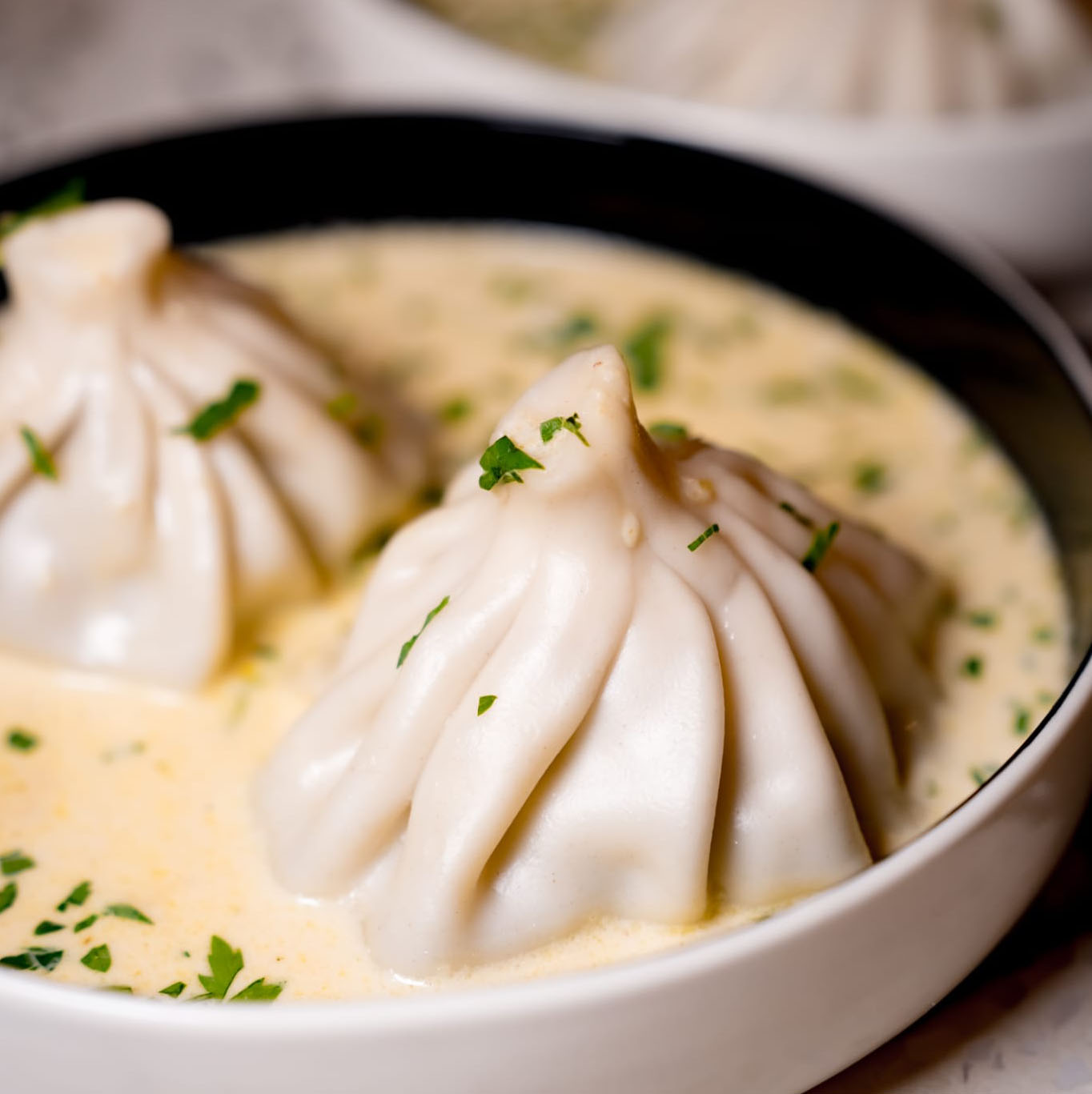 Raviolis géorgiens servis dans une sauce crémeuse aux herbes