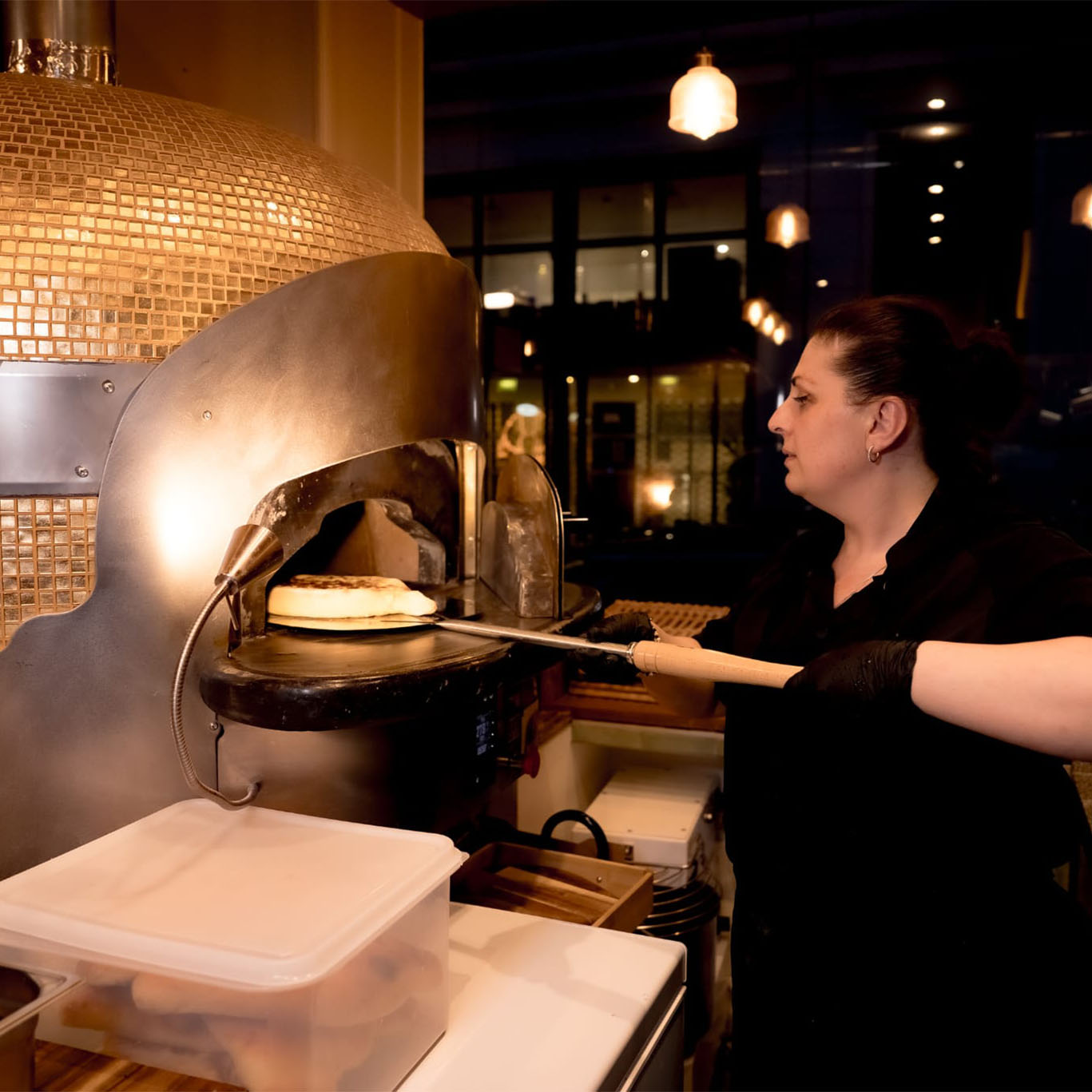 Préparation d’un pain géorgien devant le four du restaurant ODA